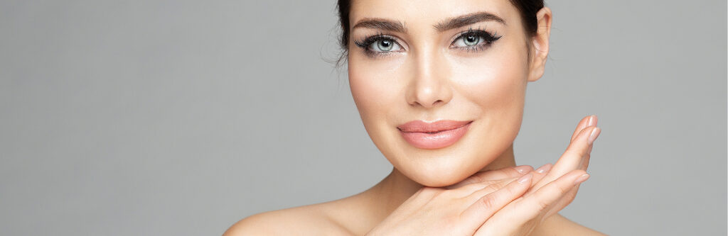 Close-up of a model's eye and brow, her fingertip at her temple